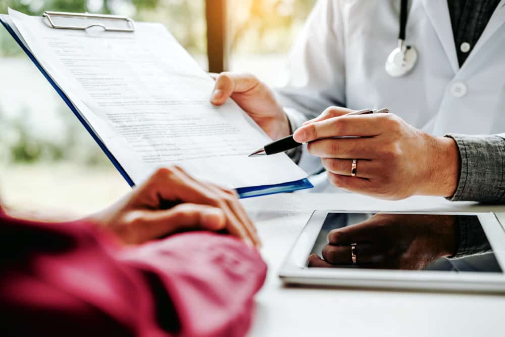 Doctors and patients sit and talk. At the table near the window in the hospital.